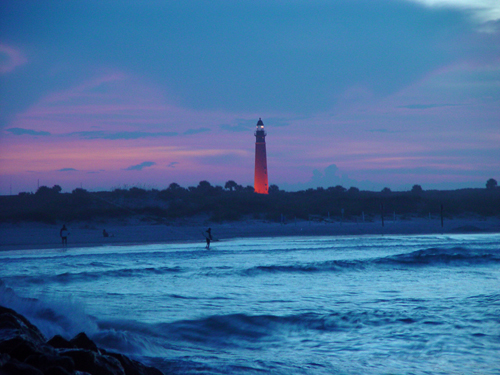 Free Picture: Photo of the Ponce Inlet Lighthouse at dusk as waves are crashing off the jetty rocks.