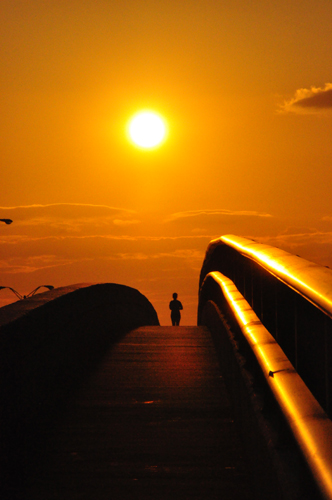 Free Picture: Photo of a runner jogging down the Dunlawtona Bridge during a beautiful orange sunset in Daytona Beach, Florida.